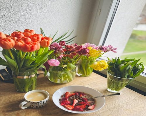 A calm breakfast table with coffee and oatmeal near a sunny window in a Polish apartment